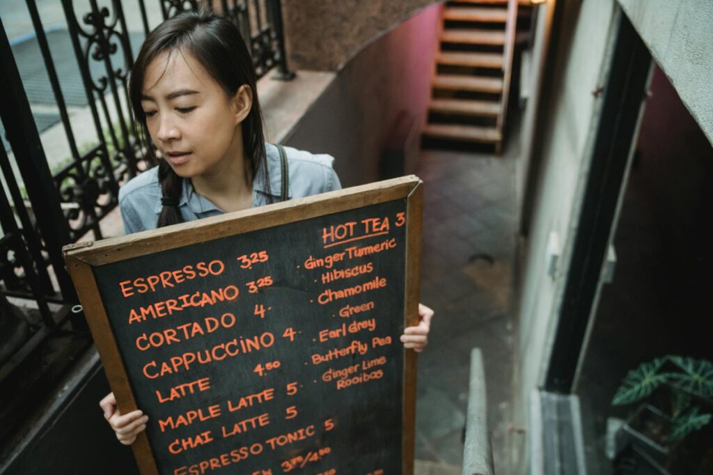 woman carrying blackboard with cafe menu