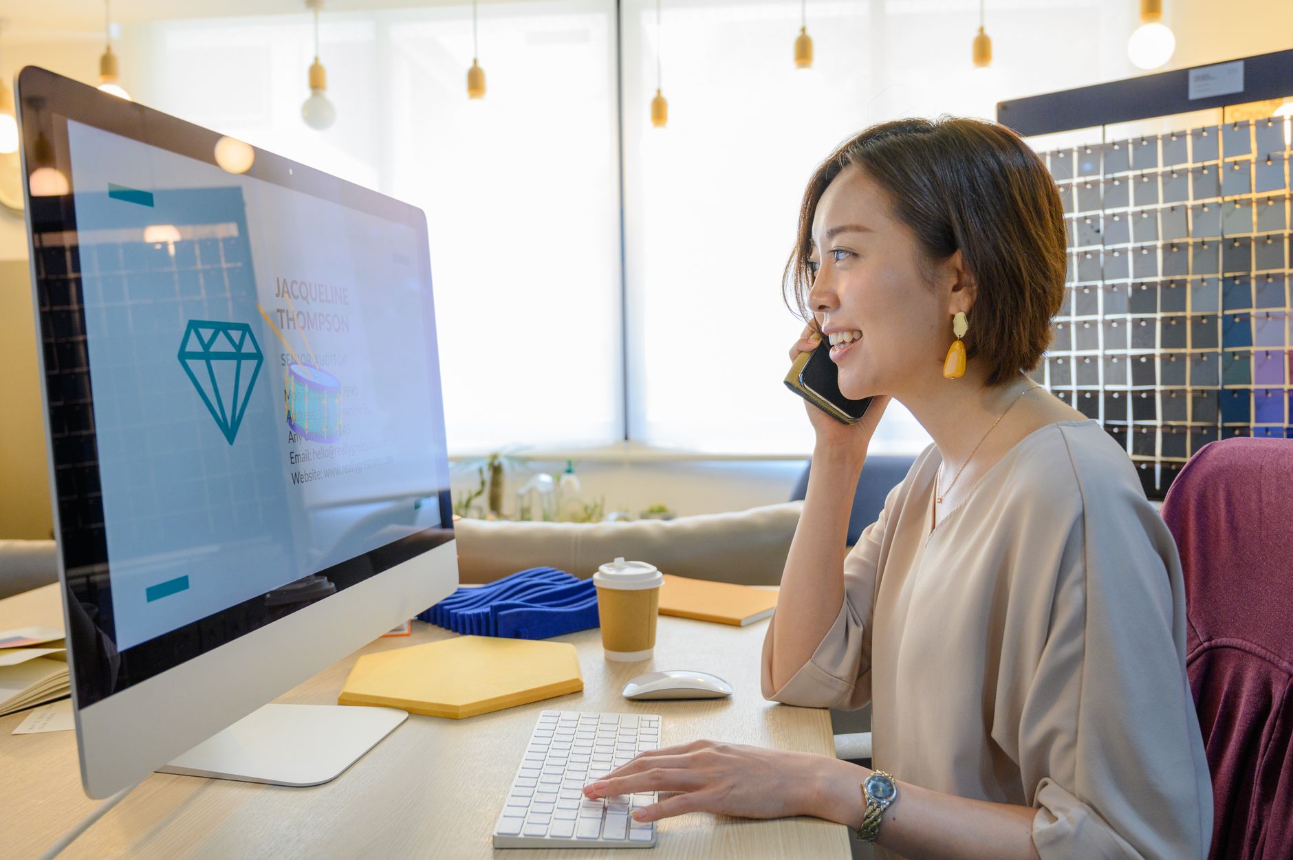woman typing on a white keyboard while talking on the smartphone