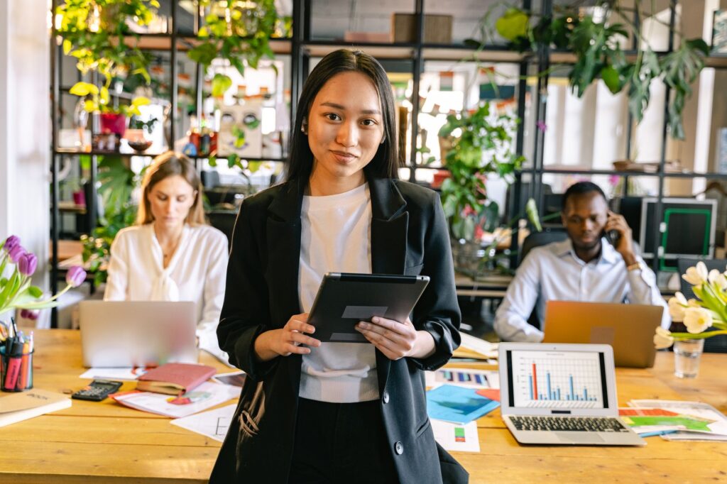 portrait of a woman wearing an office smart casual attire holding an ipad