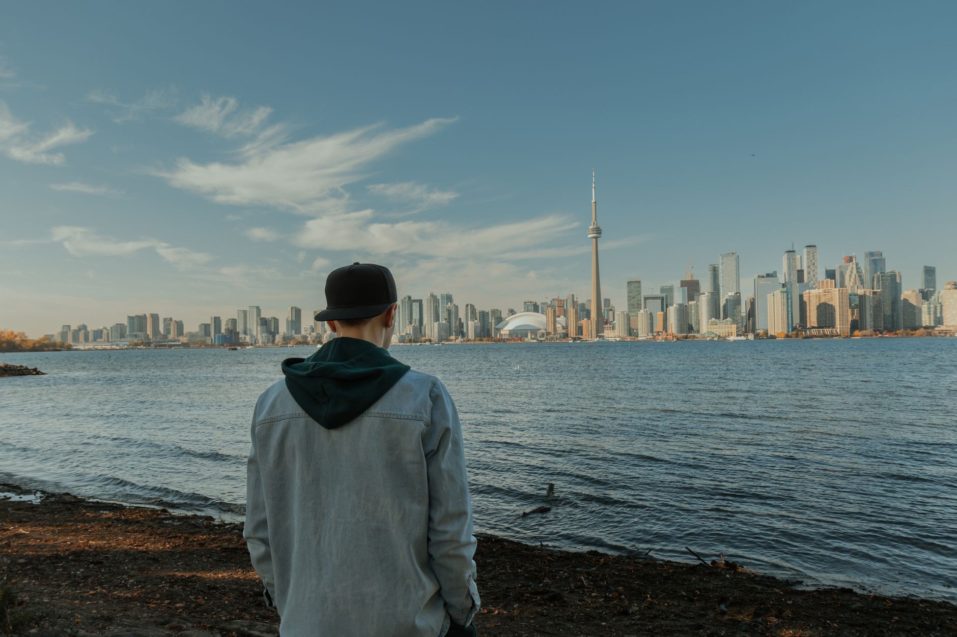 man looking at toronto skyline from waterfront